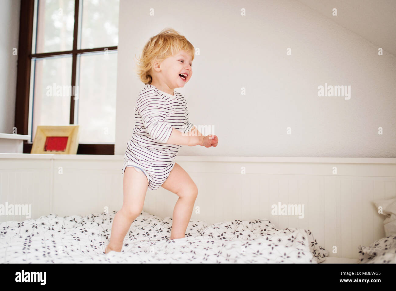 Cute toddler boy jumping on the bed in the bedroom Stock Photo Alamy