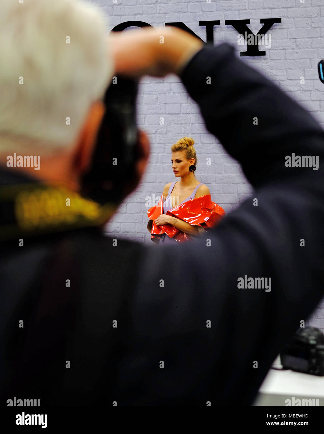 Photographers compete & jostle to take photos of a beautiful female model on a stand at the Photography Show at the NEC Birmingham in March 2018 Stock Photo