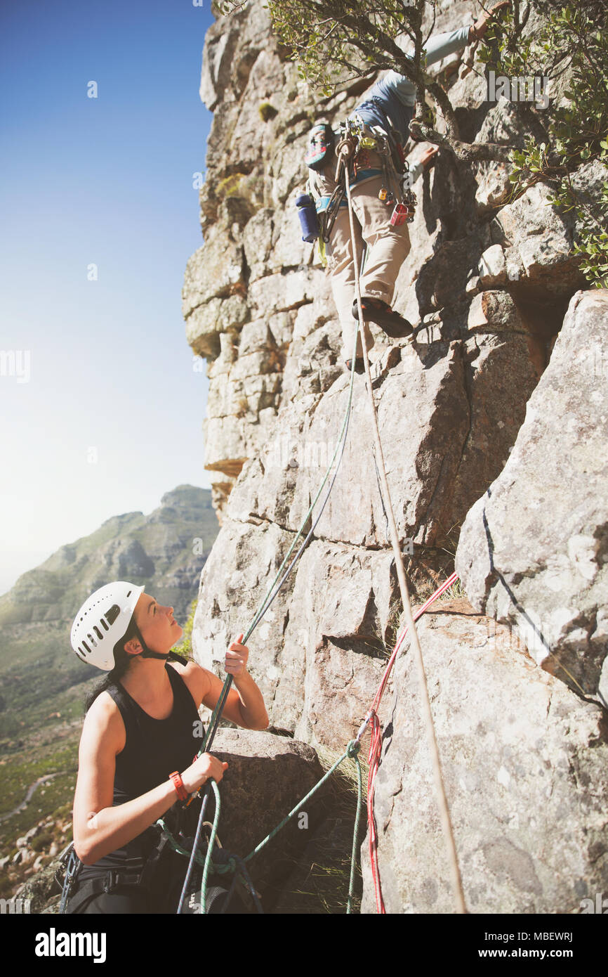 Female rock climber holding ropes for partner Stock Photo