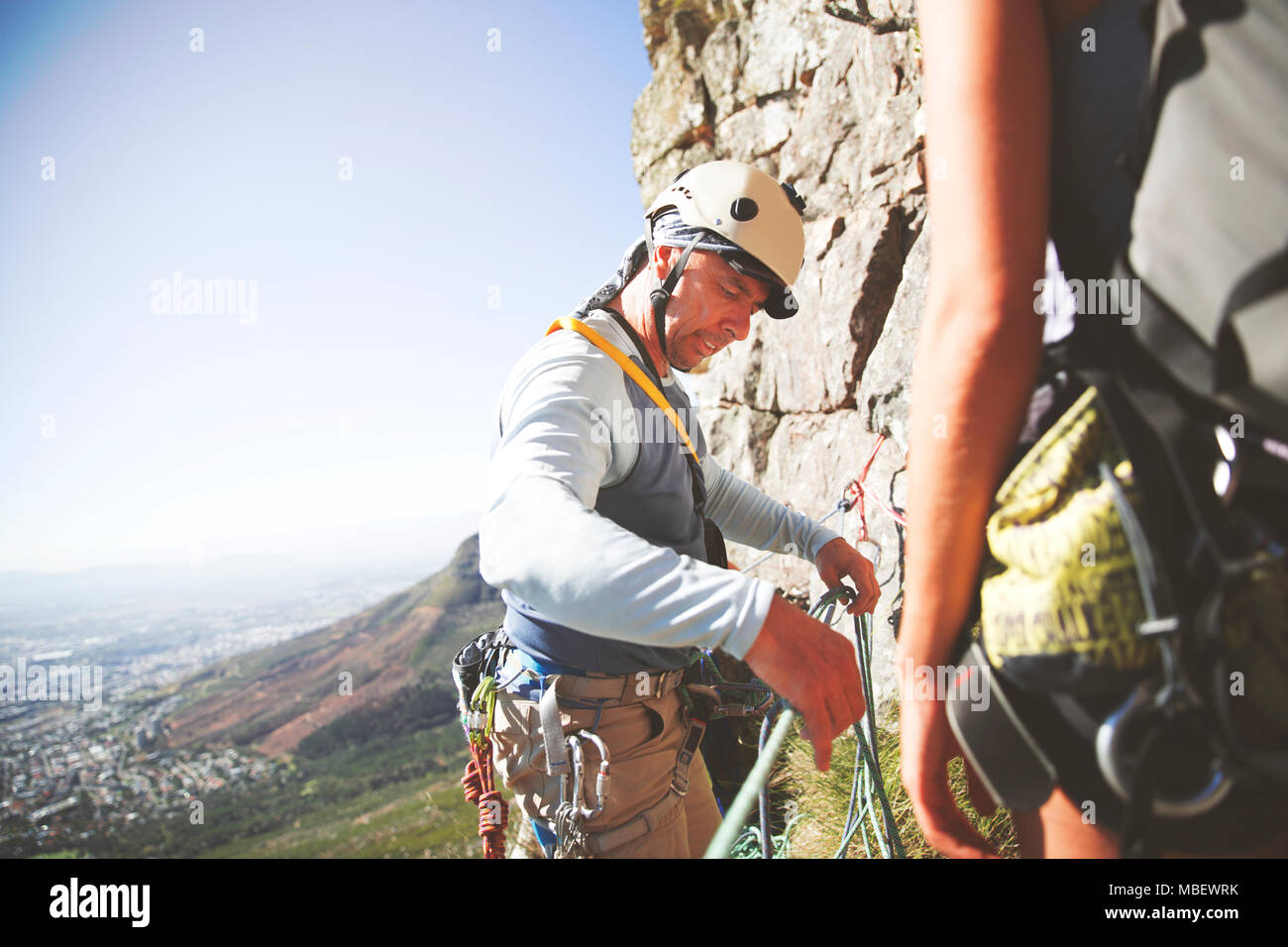 Male rock climber adjusting ropes Stock Photo