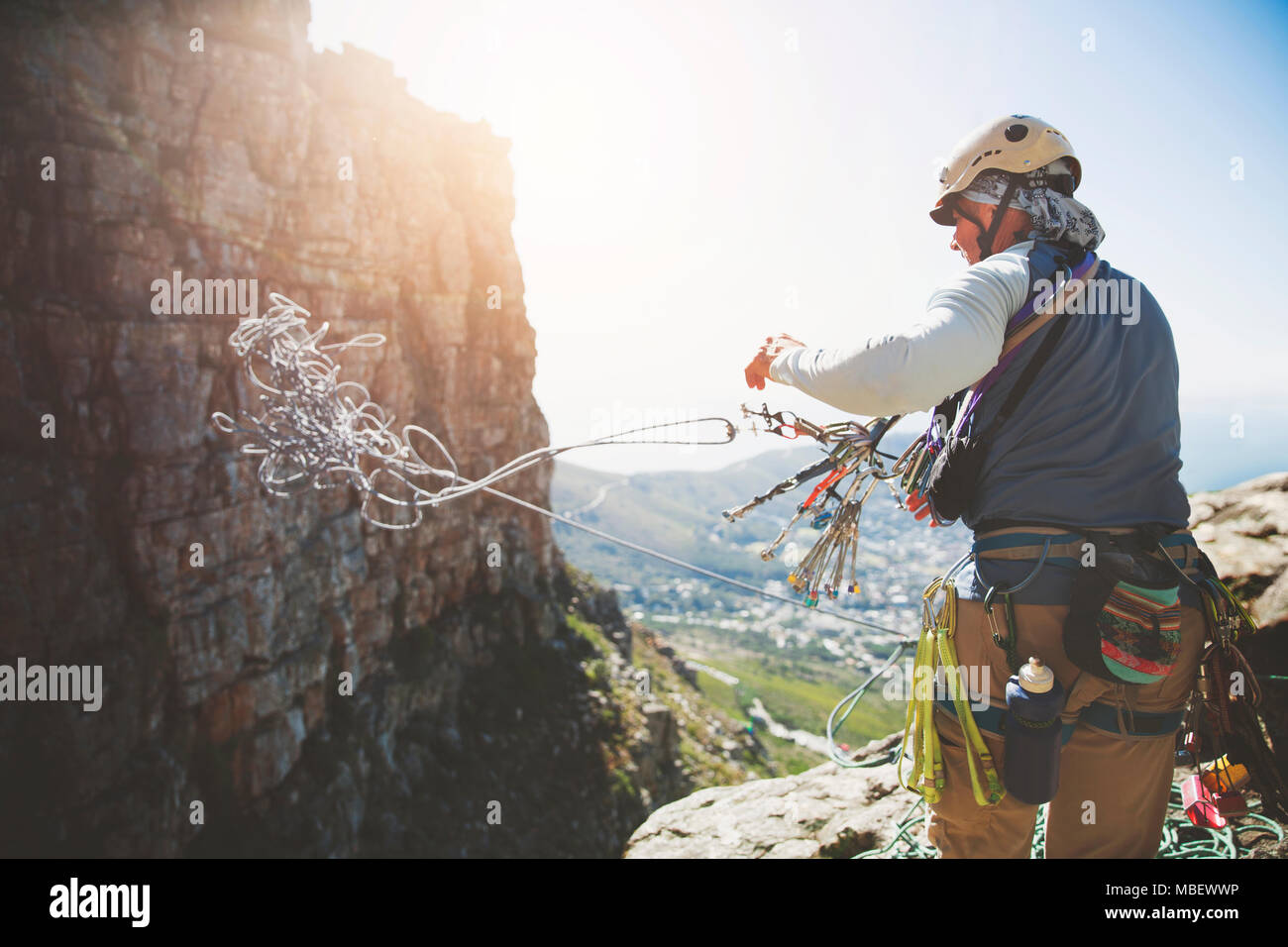 Male rock climber throwing rope Stock Photo
