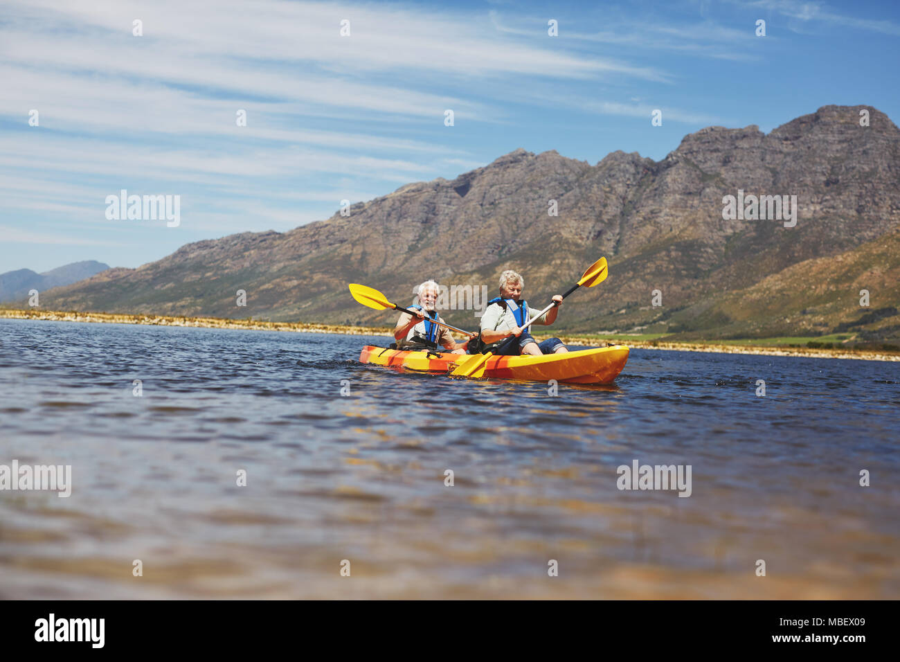 Active senior couple kayaking on sunny summer lake Stock Photo