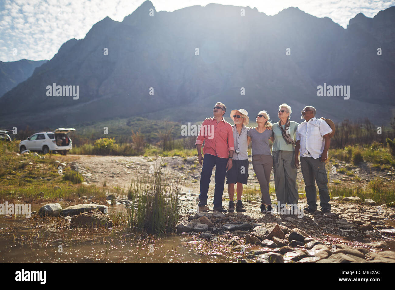 Curious active senior friends hiking, looking at craggy landscape Stock Photo