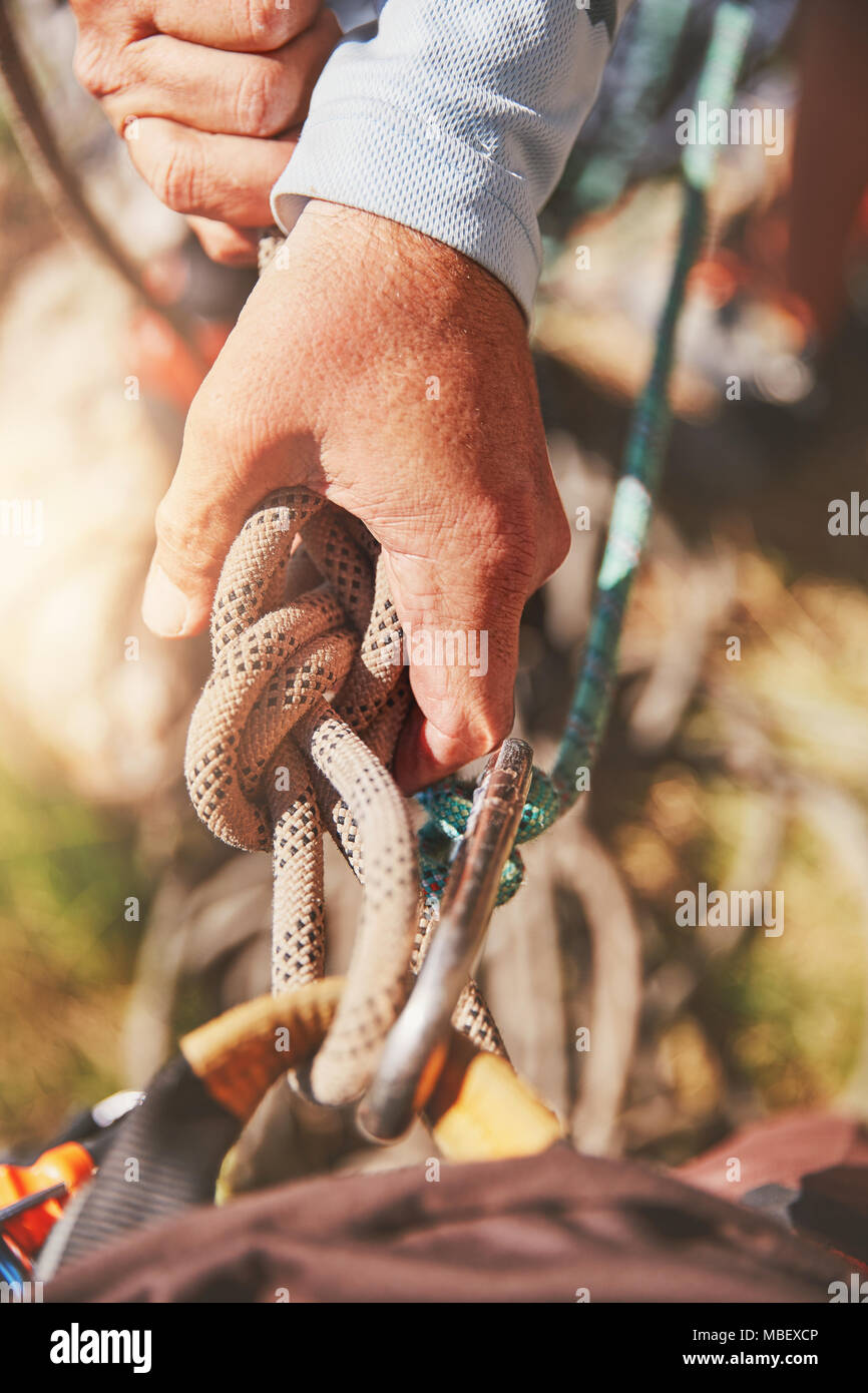Close up rock climber holding knotted rope Stock Photo