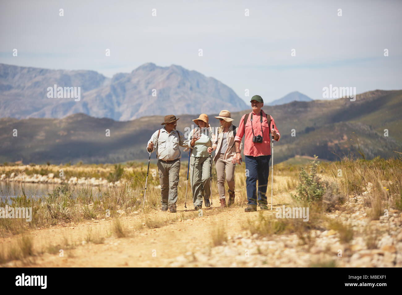 Active senior friends hiking along arid summer landscape Stock Photo