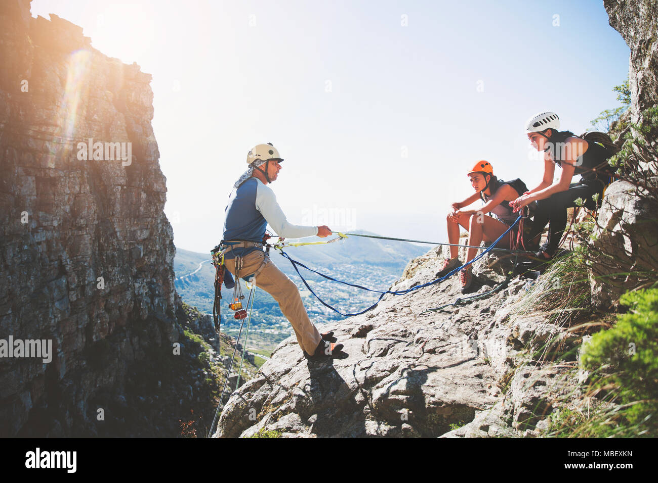 Rock climbers with ropes on sunny rock Stock Photo