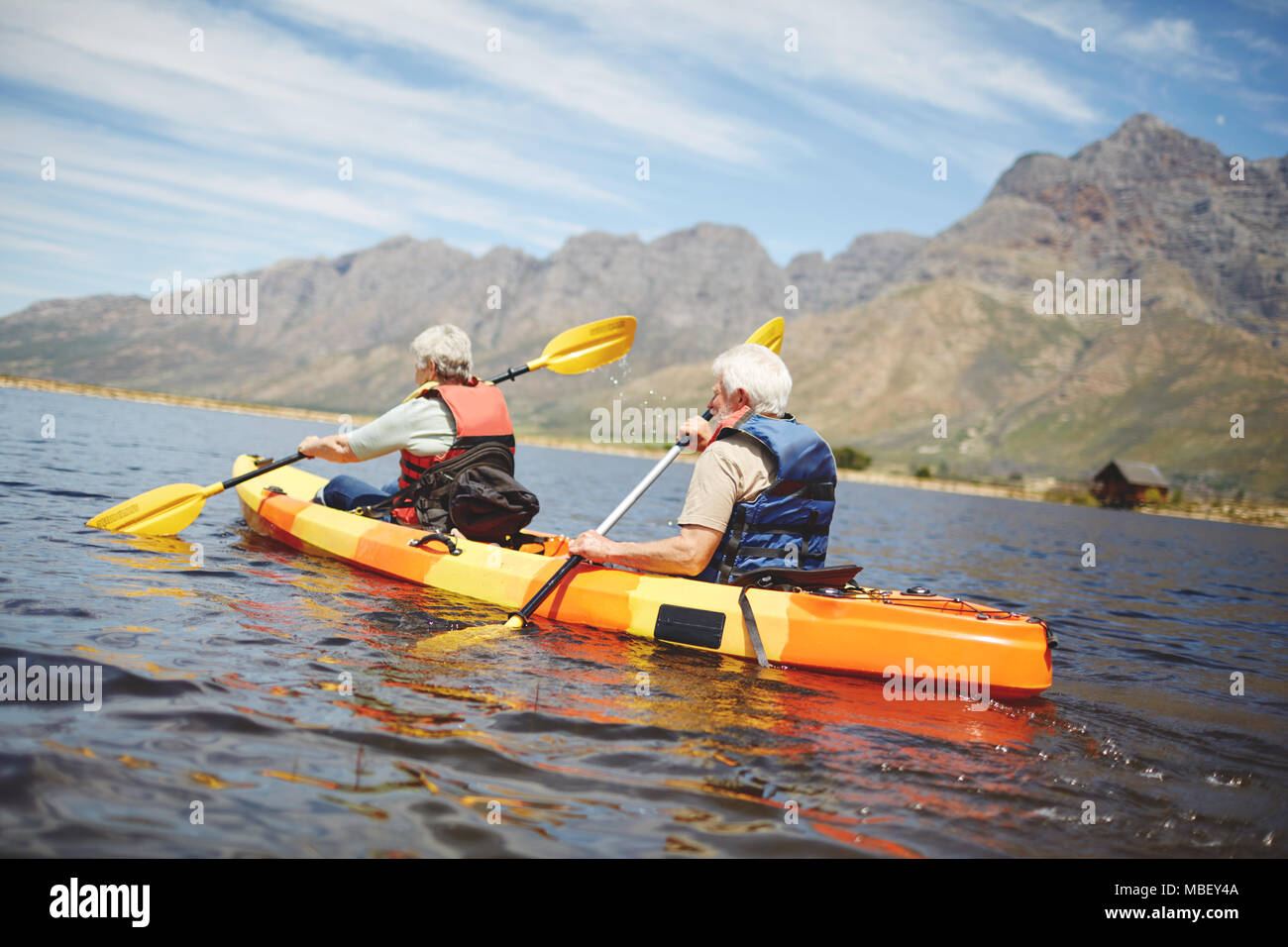 Active senior couple kayaking in sunny summer lake Stock Photo