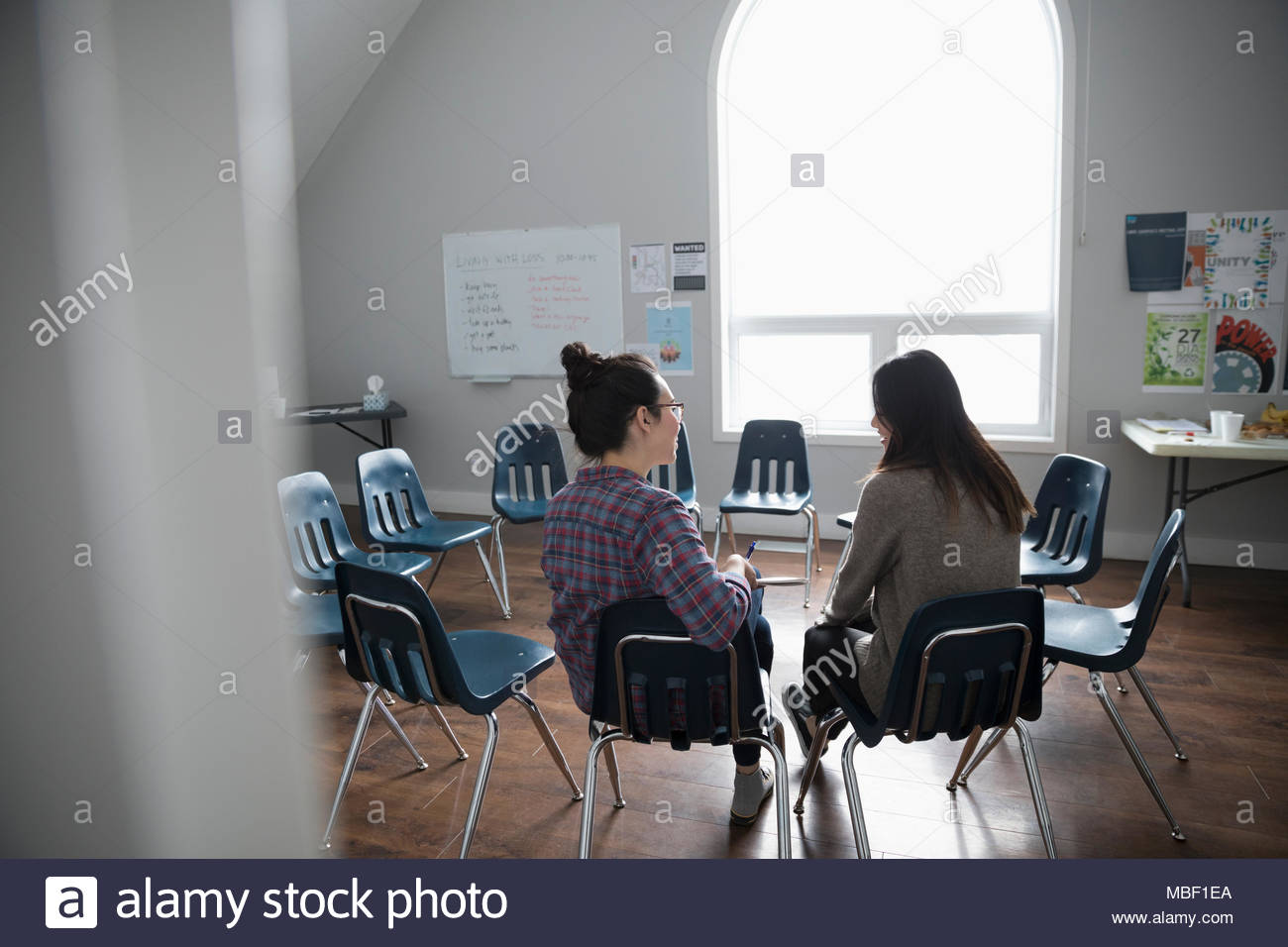 Women talking in circle at support group in community center Stock Photo