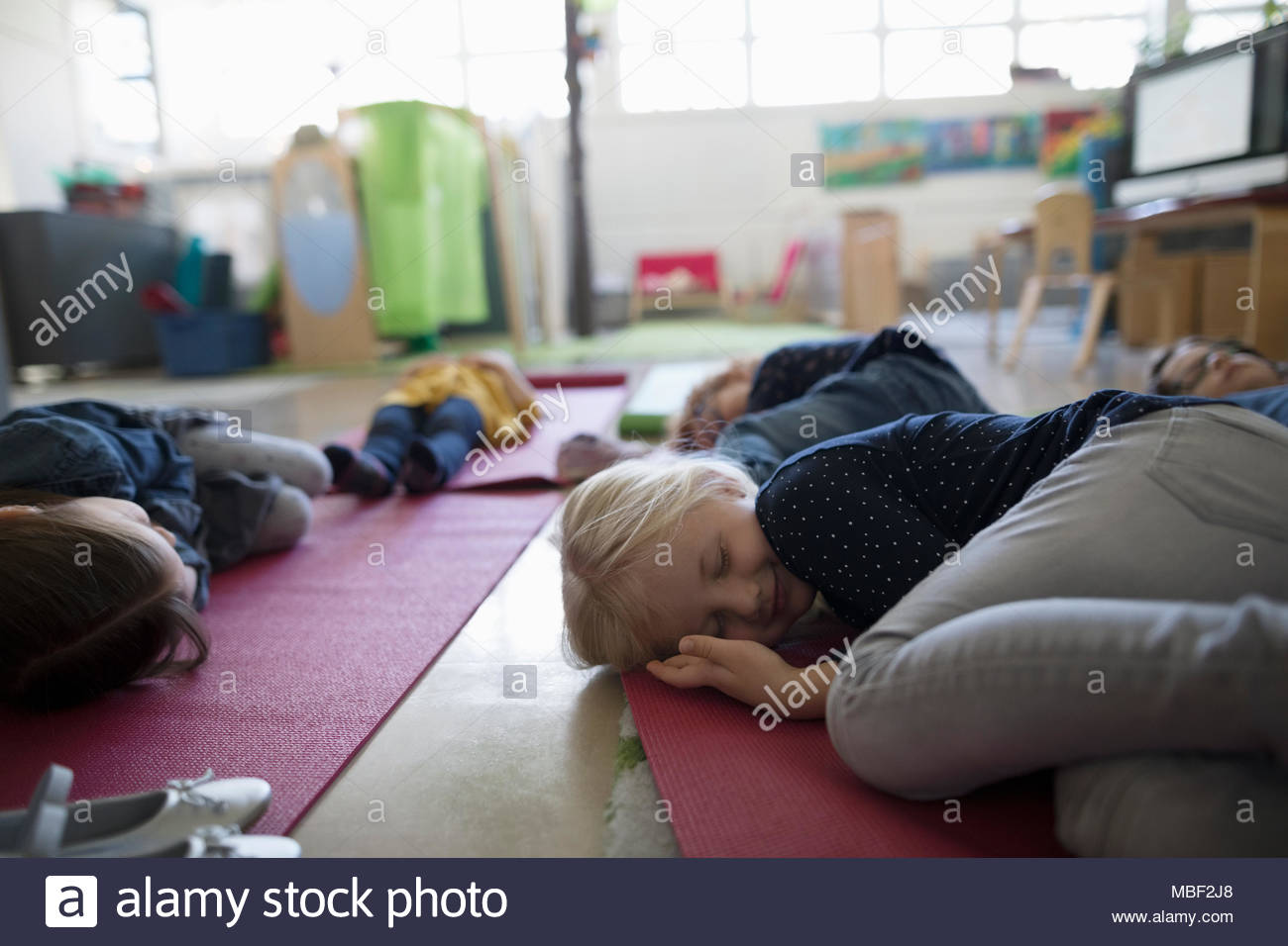 Tired preschool students sleeping on yoga mats during nap time Stock Photo Alamy