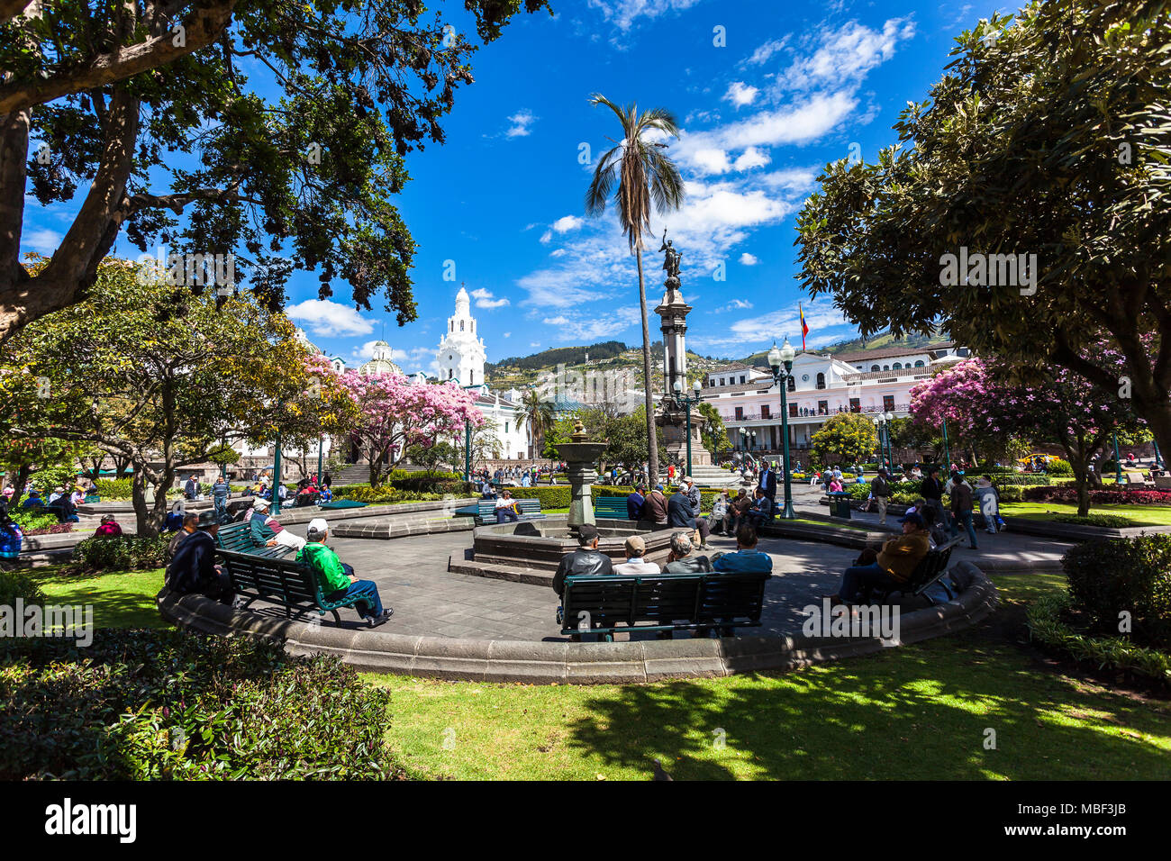 QUITO, ECUADOR - 30 JUNE, 2015: Tourists and residents rest on the benches in the Plaza de la Independencia in Quito after touring the city streets Stock Photo