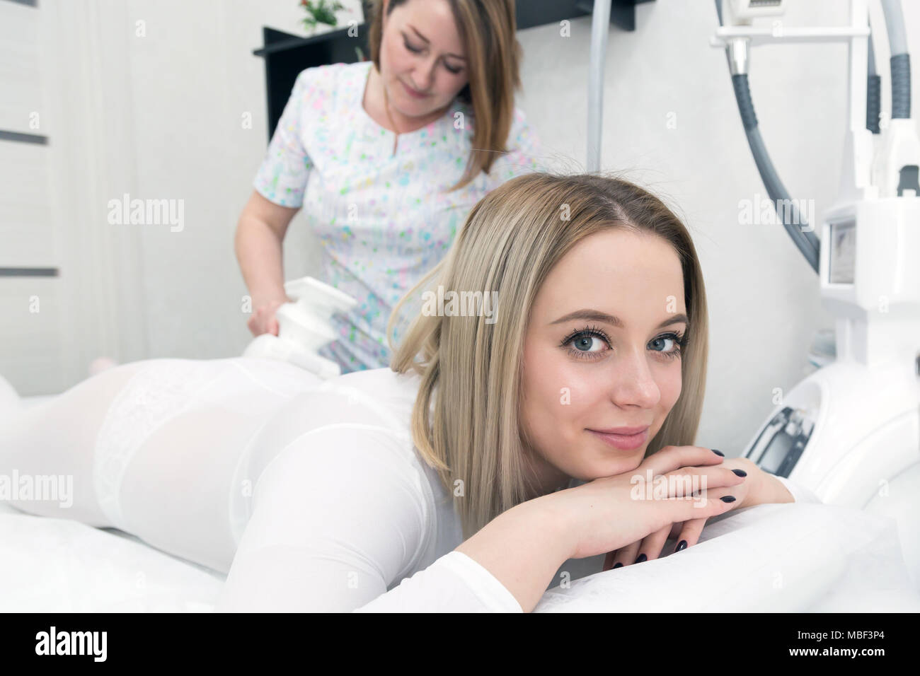 A beautiful girl with big eyes tidies up the figura with a massage in the salon. Stock Photo