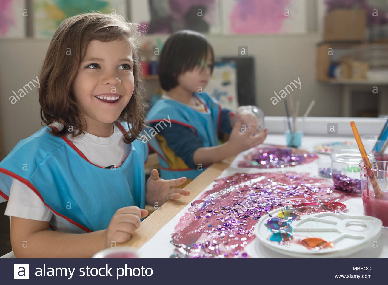 Smiling preschool girl painting in art class Stock Photo - Alamy
