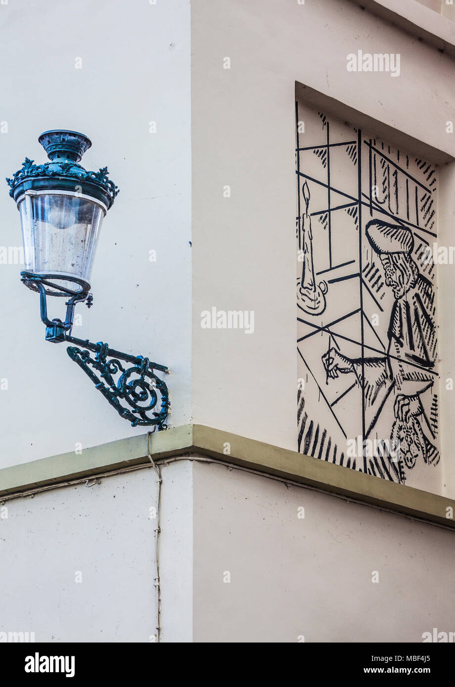 A street light and a painting on a wall in Bruges Brugge