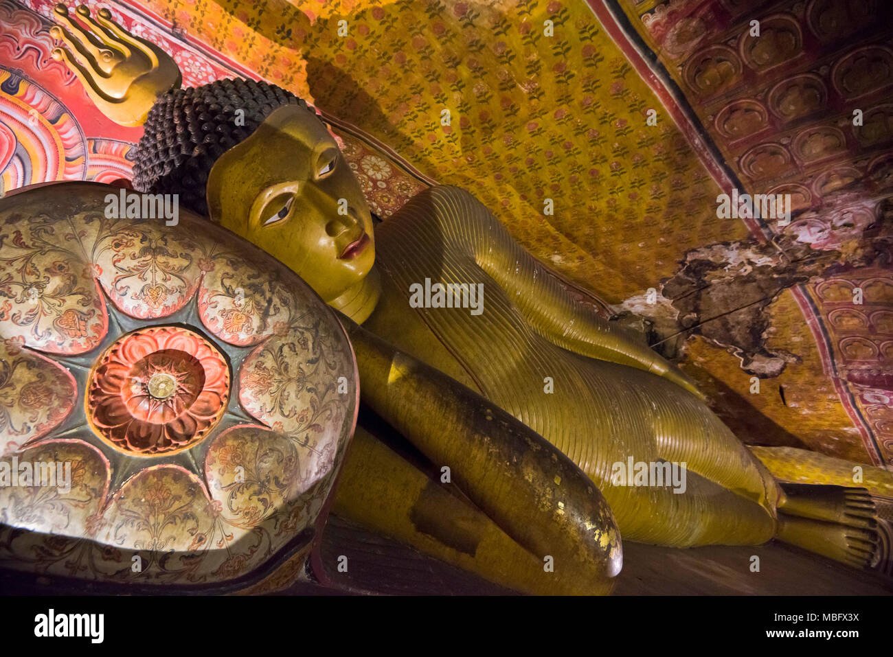 Horizontal close up of the reclining Buddha inside Maha Alut Vihara at Dambulla Cave Temple in Sri Lanka. Stock Photo