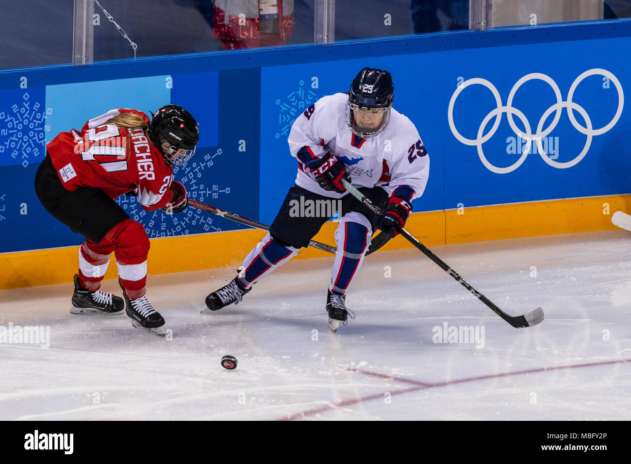 Isabel Waidacher (SUI) #24 and Jingyu Lee (KOR) #29 during Korea (combinded) vs Switzerland Women's Ice Hockey competition at the Olympic Winter Games Stock Photo