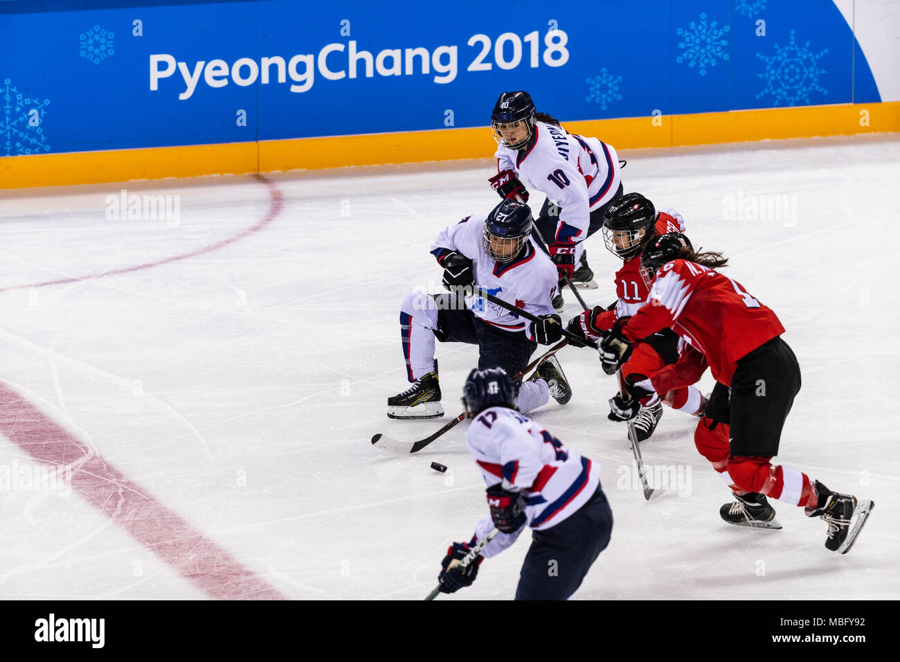 Su Hyon Jong (KOR) #27 and Sabrina Zollinger (SUI) #11 and  and Jiyeon Choi (KOR) #10 during Korea (combinded) vs Switzerland Women's Ice Hockey compe Stock Photo