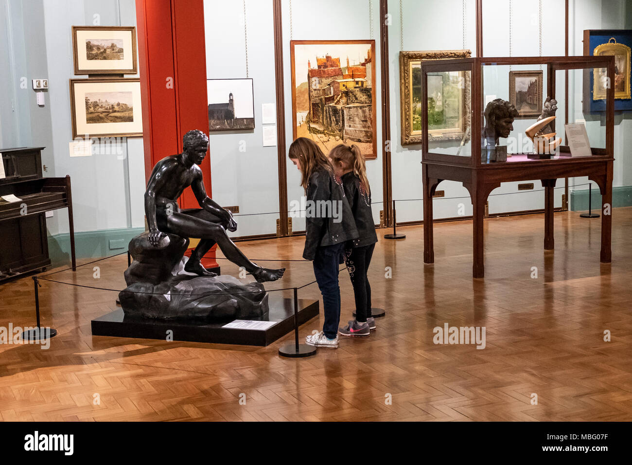 Two young girls looking at Art and Sculptures inside Cliffe Castle Museum, Keighley, Bradford, Yorkshire, United Kingdom. Stock Photo