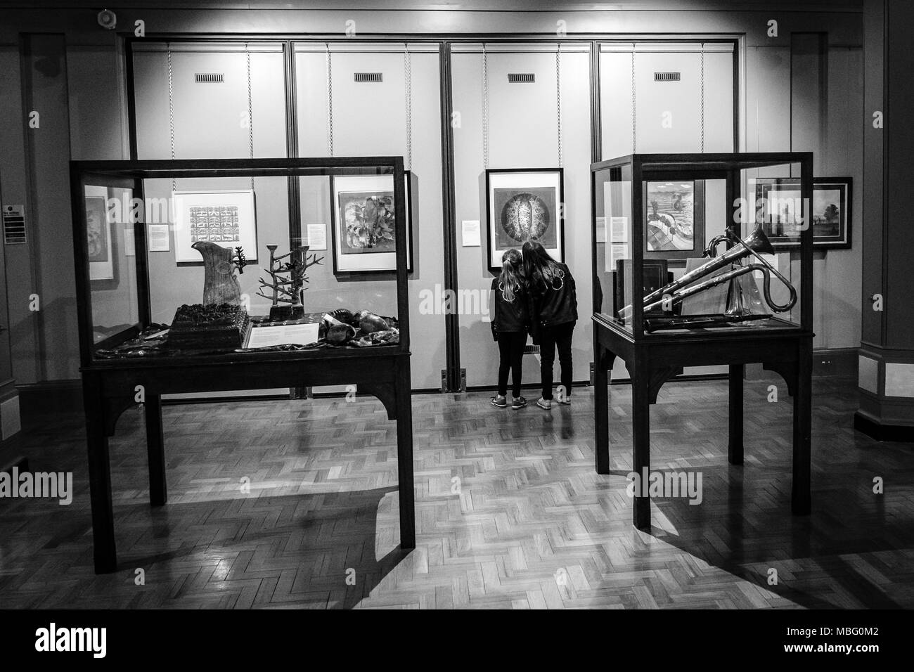 Two young girls looking at Art and Sculptures inside Cliffe Castle Museum, Keighley, Bradford, Yorkshire, United Kingdom. Stock Photo