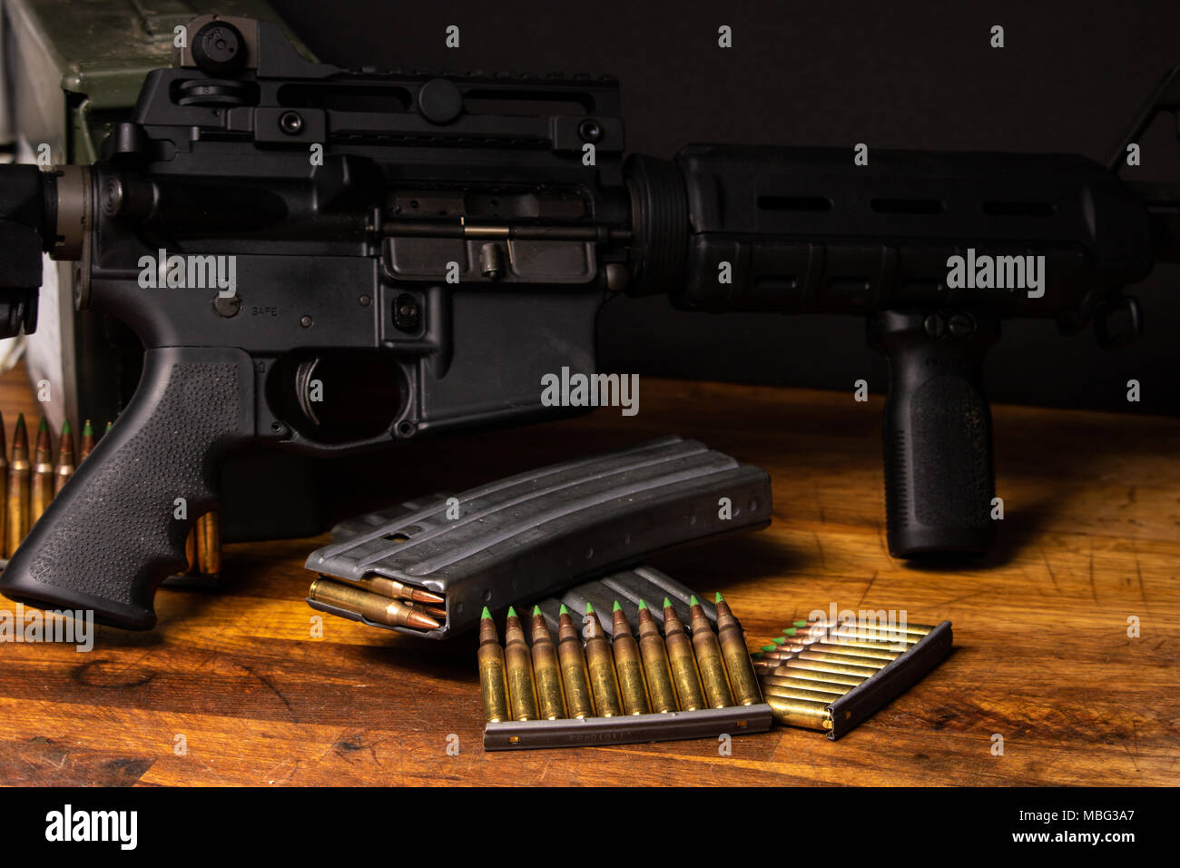 Dark setting with an AR-15 with 5.56 ammunition and magazines Stock Photo