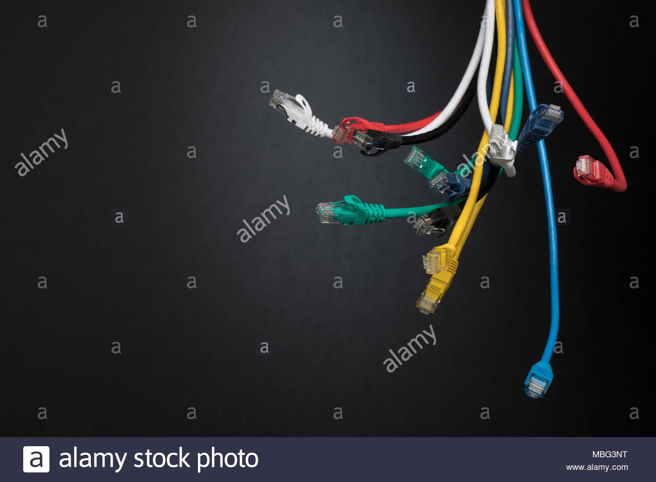 Contrasting multicolor computer cables dangling in bundle Stock Photo
