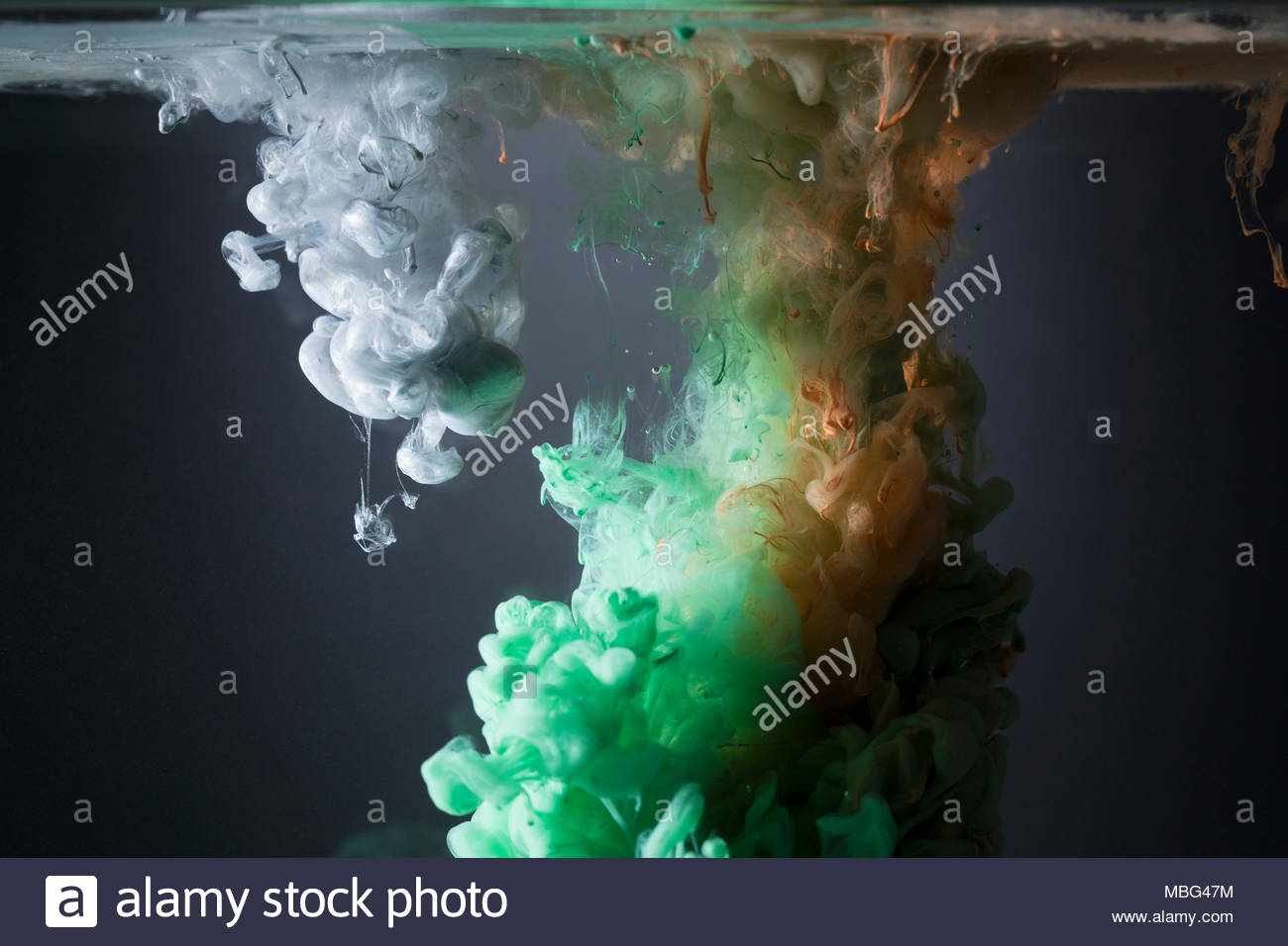 Creative green, orange and white liquid blending underwater Stock Photo