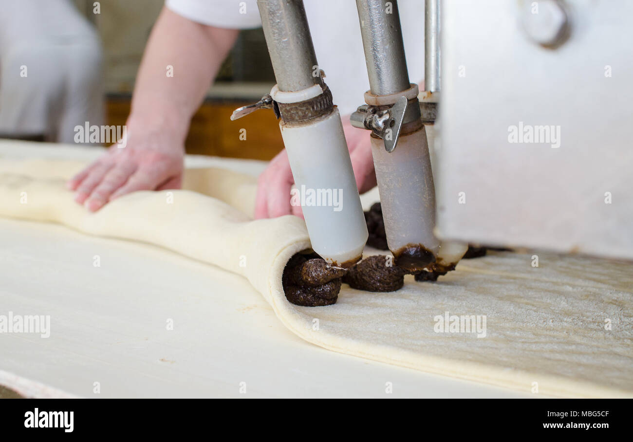 Working on a sweet pastry in a big industrial bakery. Stock Photo