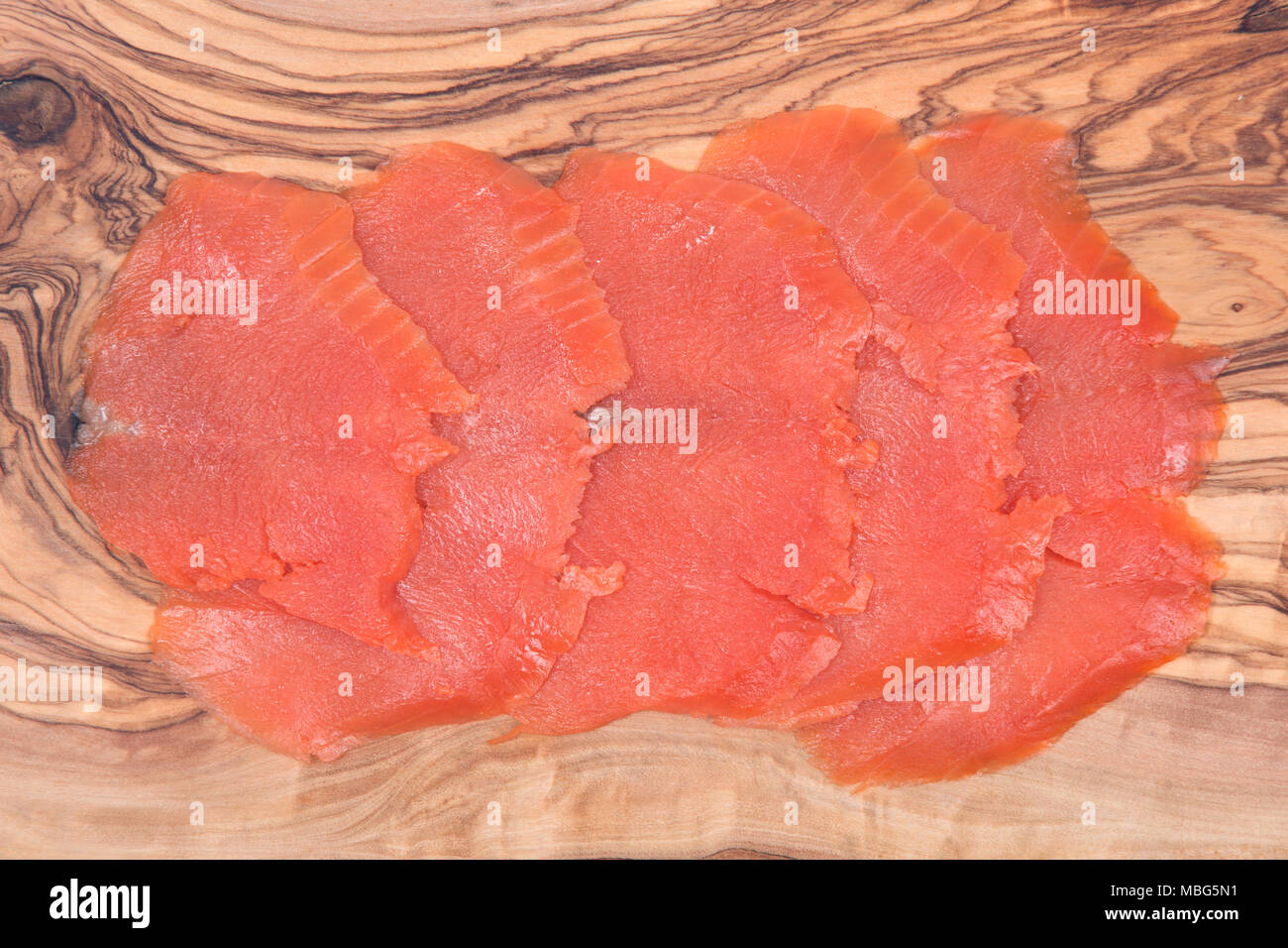 Smoked wild pacific sockeye salmon on olive wood cutting board