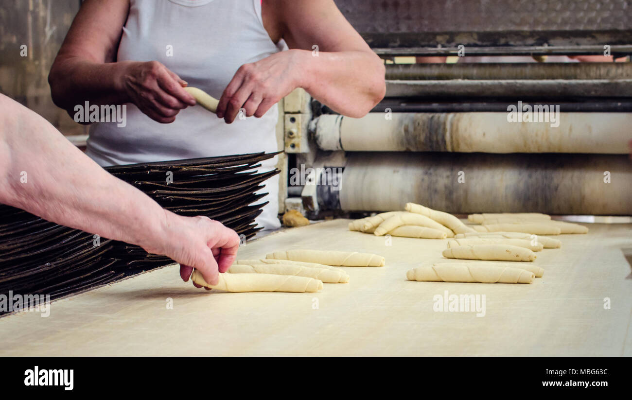 Working on a sweet pastry in a big industrial bakery. Stock Photo