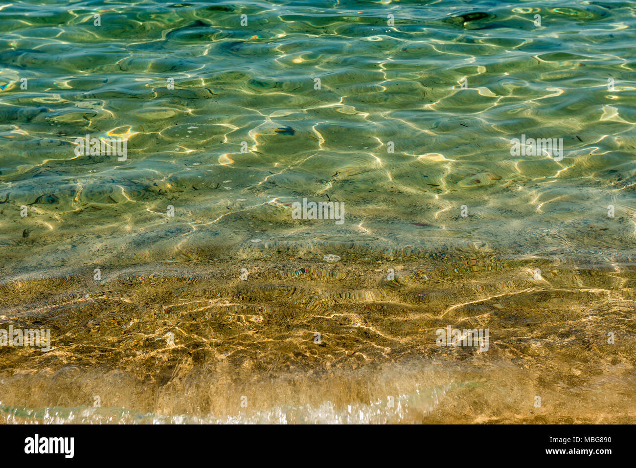 Reflections and refractions in the water of the Mediterranean sea shore of yellow and green colors near Colonia de Sant Jordi, Mallorca Stock Photo