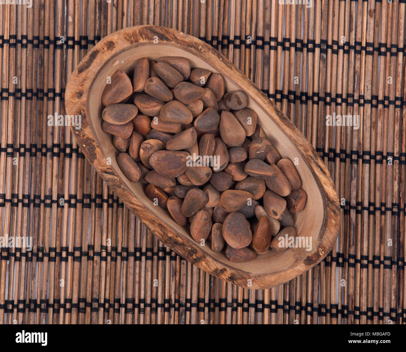 Organic pine nuts in shell in olive wood bowl Stock Photo Alamy