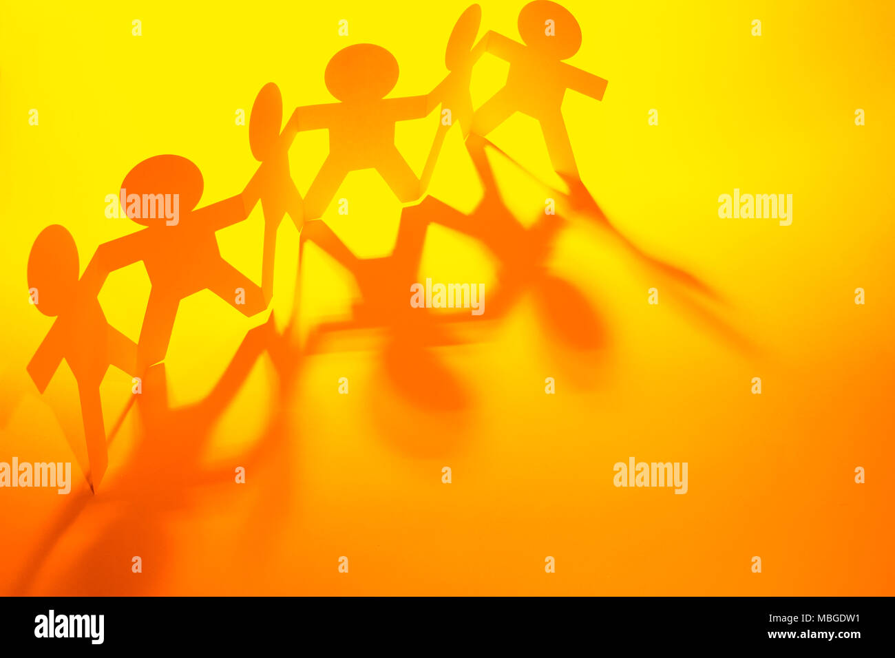 Team of paper chain people in a row holding hands Stock Photo - Alamy
