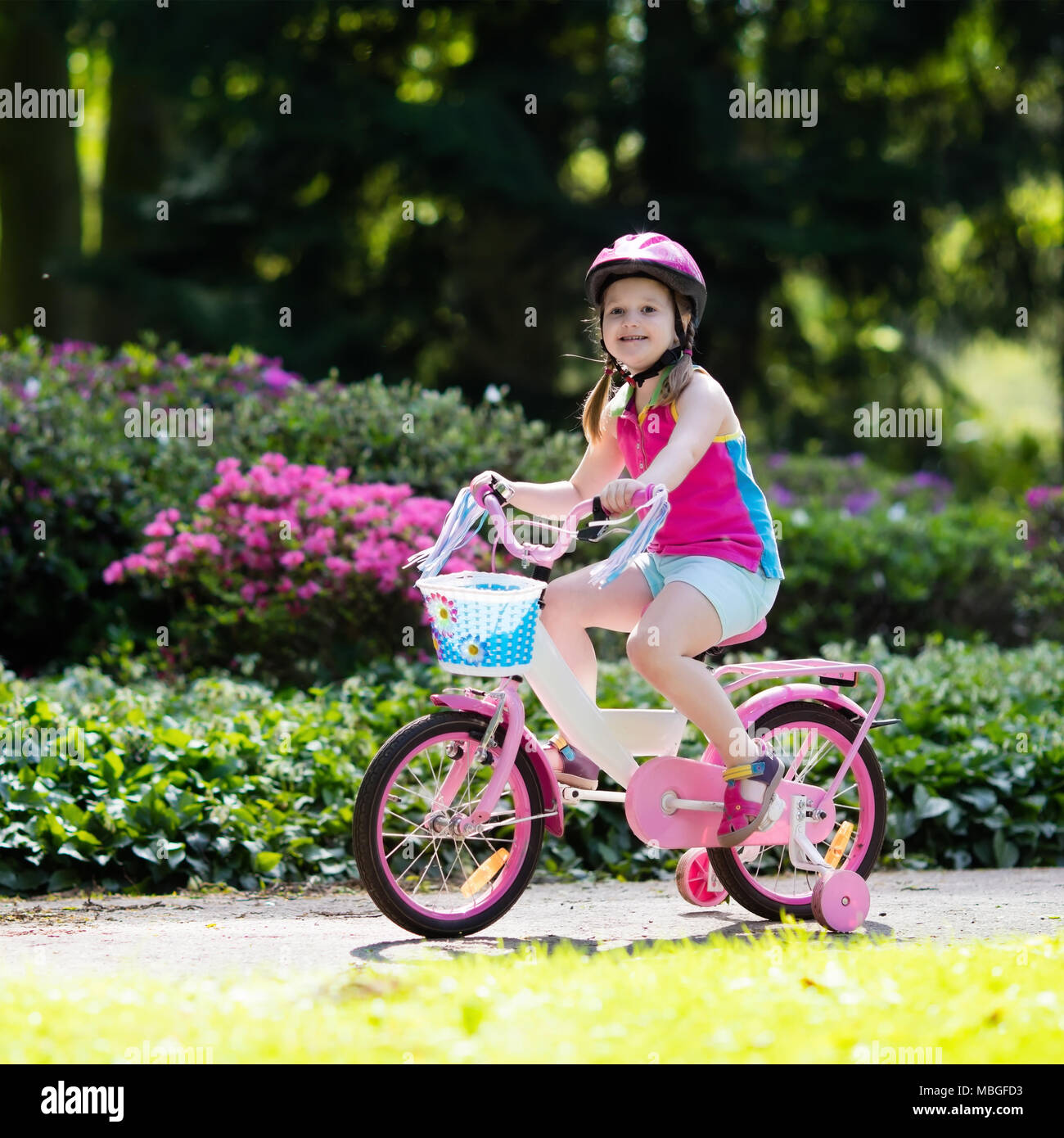 Child riding bike. Kid on bicycle in sunny park. Little girl enjoying bike ride on her way to school on warm summer day. Preschooler learning to balan Stock Photo Alamy