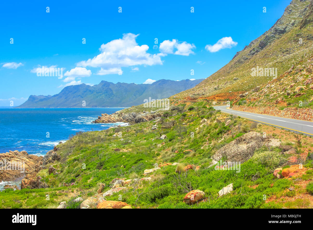 Scenic coastal Route 44 or Clarence Drive on False Bay near Cape Town between Gordon's Bay and Pringle Bay in Western Cape, South Africa. Hottentots Holland Mountain range on background. Summer season Stock Photo