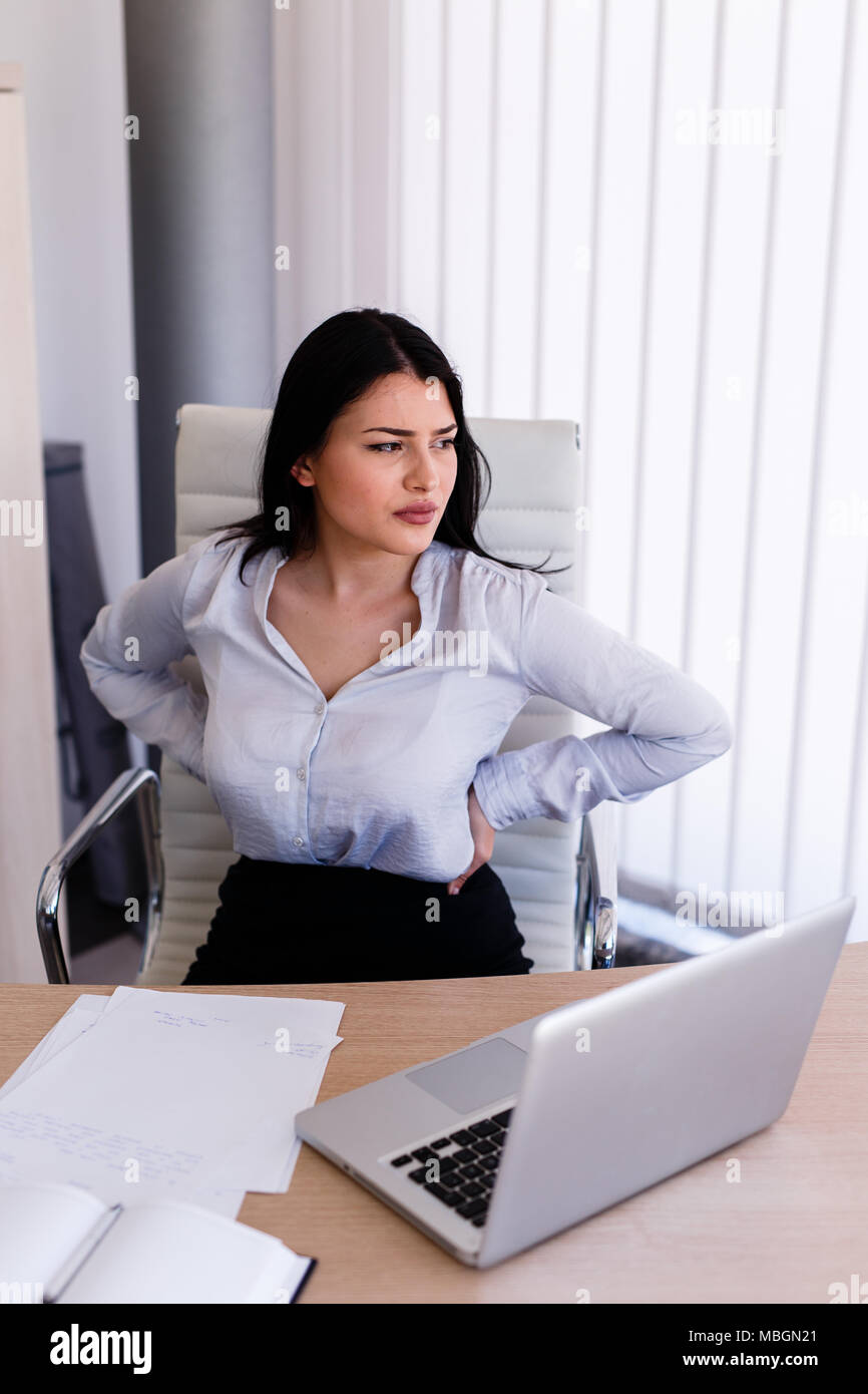 Businesswoman having back pain after long sitting in her office Stock ...