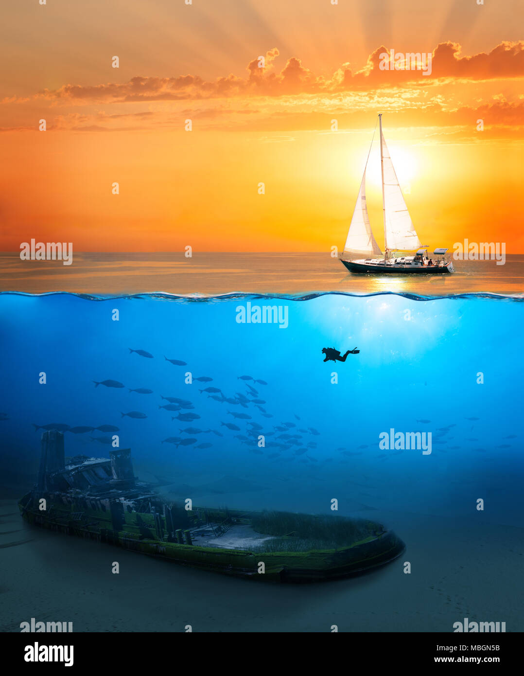 Half underwater shot with diver exploring wreck and yacht sailing at sunset Stock Photo
