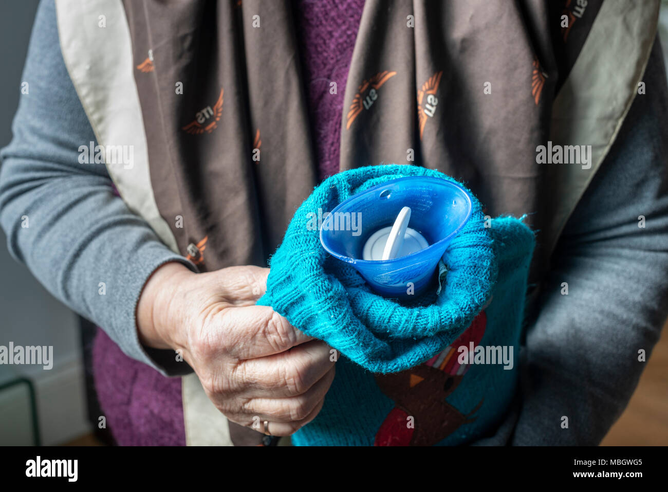 Senior woman holds hot water bottle-close-up Stock Photo