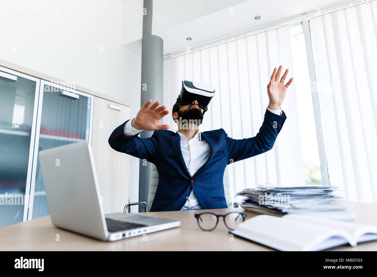 Young Businessman Using VR At Workplace Stock Photo