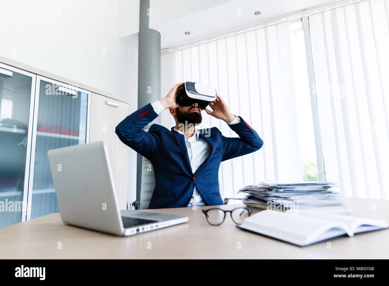 Young Businessman Using VR At Workplace Stock Photo