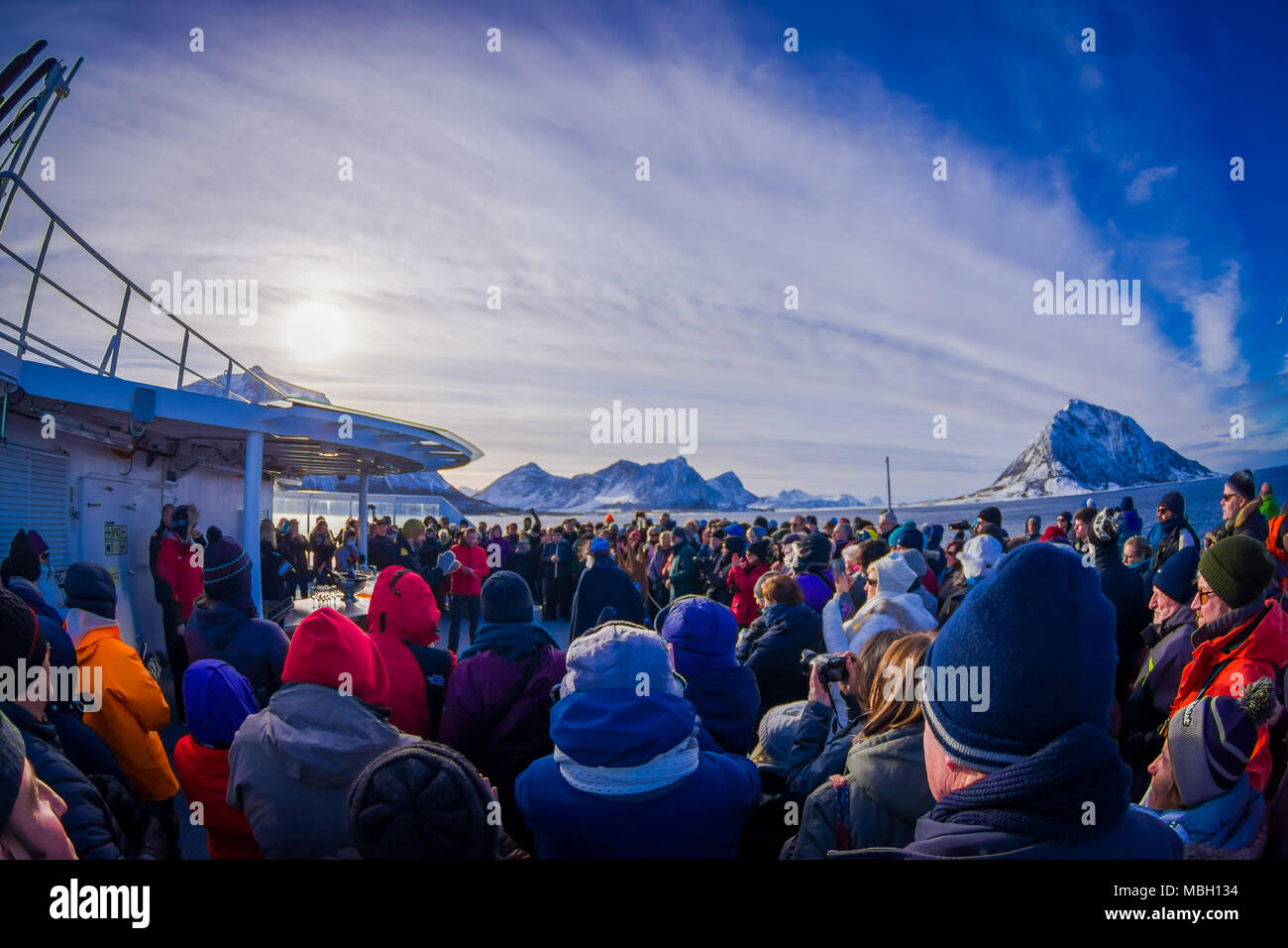 ALESUND, NORWAY - APRIL 04, 2018: Outdoor view of crowd of people in a KONG HARALD cruise enjoying and spending good time with other passengers, in Norway's coast between Bergen and Kirkenes Stock Photo