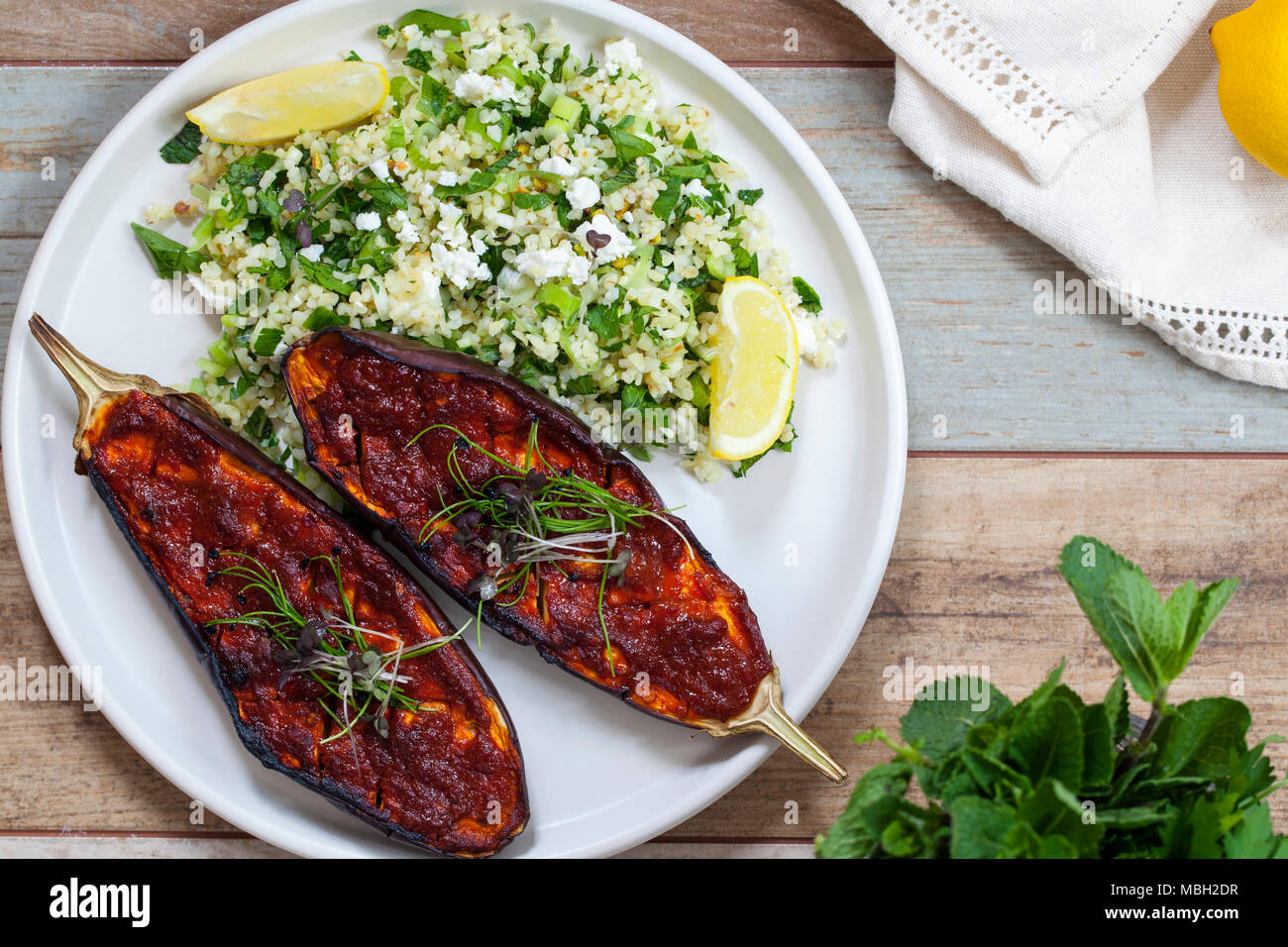 Harissa baked aubergine with bulgur wheat tabbouleh Stock Photo Alamy