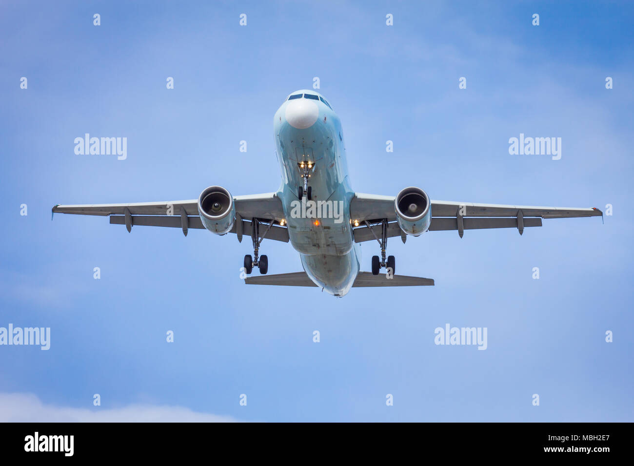 Plane about to land with a blue sky Stock Photo