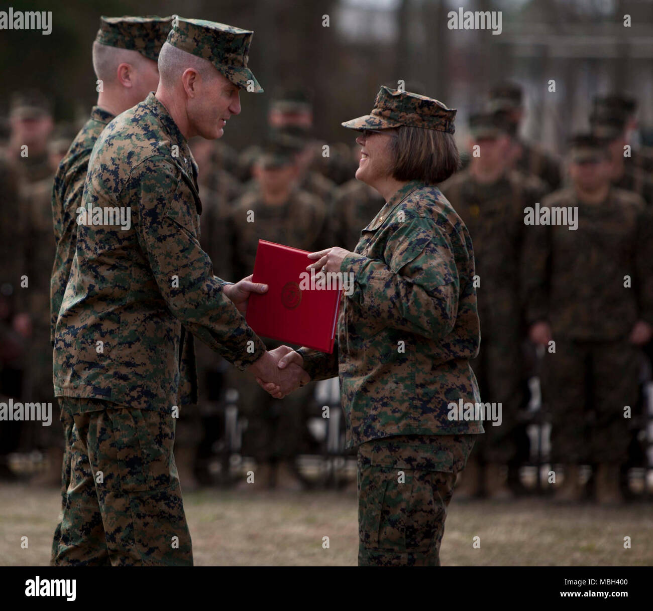 U.S. Marine Corps Training Command Commanding General Brig. Gen. Jason Q. Bohm, left, awards the Legion of Merit to U.S. Navy Capt. Jennifer E. Smith during the Field Medical Training Battalion-East (FMTB-E) Change of Command ceremony at Camp Johnson, N.C., Jan. 9, 2018. The change of command ceremony is a time-honered tradition in which one commander reliquishes command to another. Stock Photo