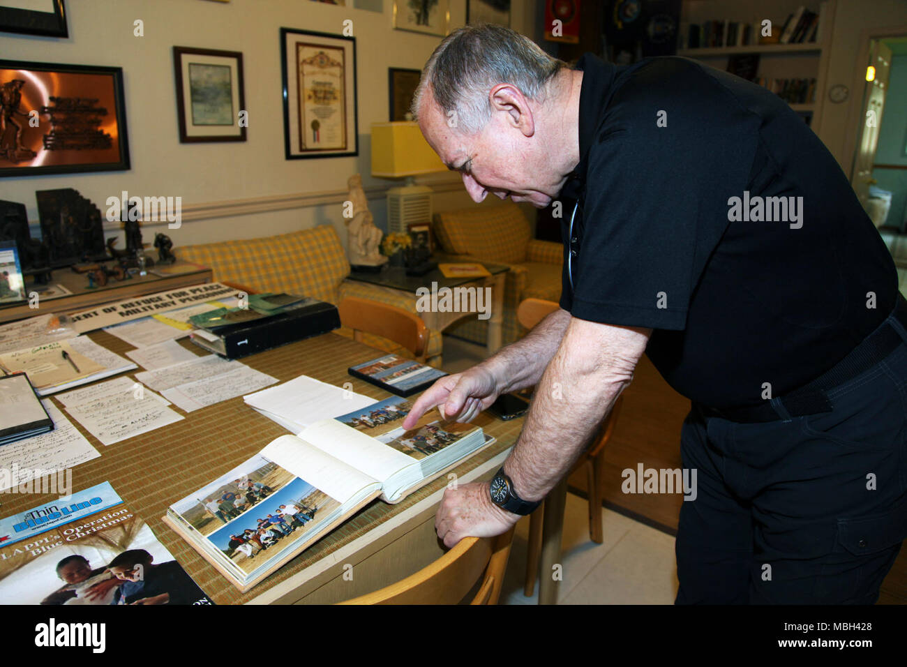 Father Michael McCullough, founder of the Desert Refuge for Peace Officers and Military Personnel, shows photos of events held at the Joshua Tree, Calif., facility during a tour March 7, 2018. McCullough is a Catholic priest and Los Angeles Police Department chaplain. Stock Photo
