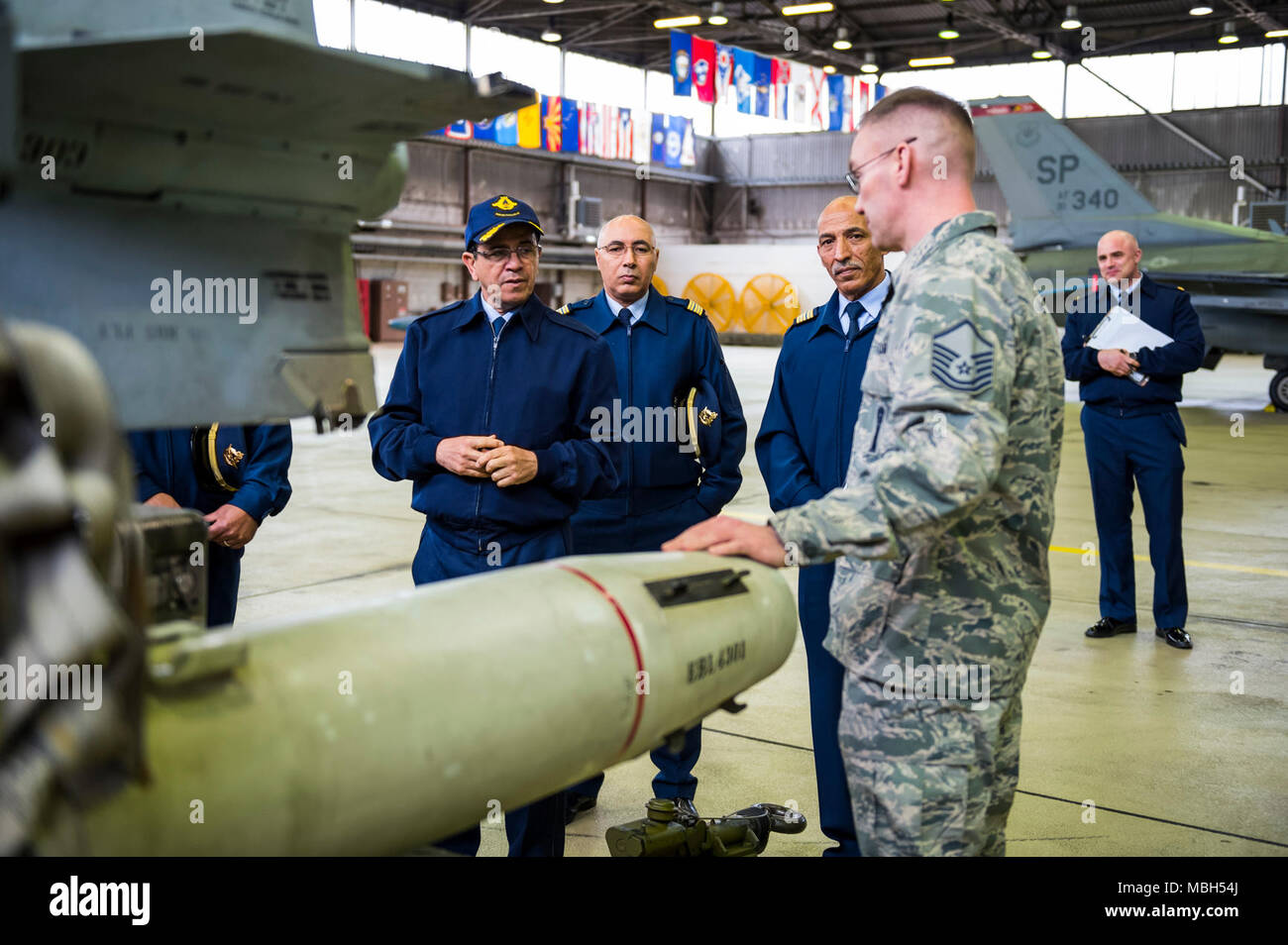 Maj. Gen. Hassan Fakri, Royal Moroccan Air Force deputy inspector, is given a tour by Master Sgt. Jason Tremmel, 52nd Maintenance Group load standardization crew team chief, of the various dummy weapons at Spangdahlem Air Base, Germany, March 28, 2018. Senior leaders from the RMAF spent time learning about the best practices of the 52nd MXG, Operations Group and the 480th Fighter Squadron. Stock Photo