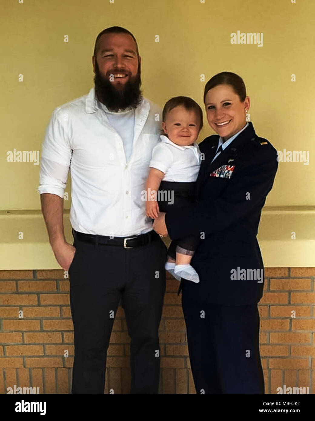 U.S. Air Force 2nd Lt. Sam Norville, a force support officer with the 182nd Airlift Wing, Illinois Air National Guard, poses for a photo with her spouse and child after graduating from Total Force Officer Training in  Maxwell Air Force Base, Ala., March 10, 2017. She served as an enlisted air transportation specialist before the military funded her bachelor’s degree through the Illinois National Guard Grant, leading her to commissioning. Stock Photo