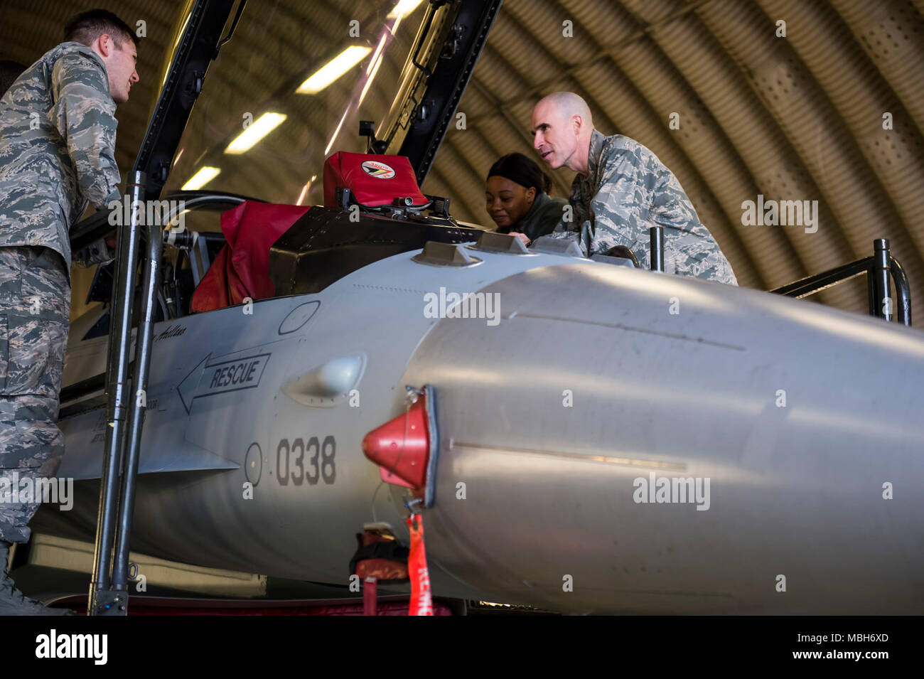 U.S. Air Force Col. Jason Bailey, 52nd Fighter Wing commander, explains the functions of an F-16 Fighting Falcon to Senior Airman Tyler MacMillan, (left), 52nd Logistics Readiness Squadron material handling equipment journeyman, and Airman 1st Class Leah Crawford, (right), 52nd LRS fleet management analyst journeyman, at Spangdahlem Air Base, Germany, April 4, 2018. The tour gave Airmen from around the 52nd FW the opportunity to meet the command team and expand their knowledge of flightline operations. Stock Photo