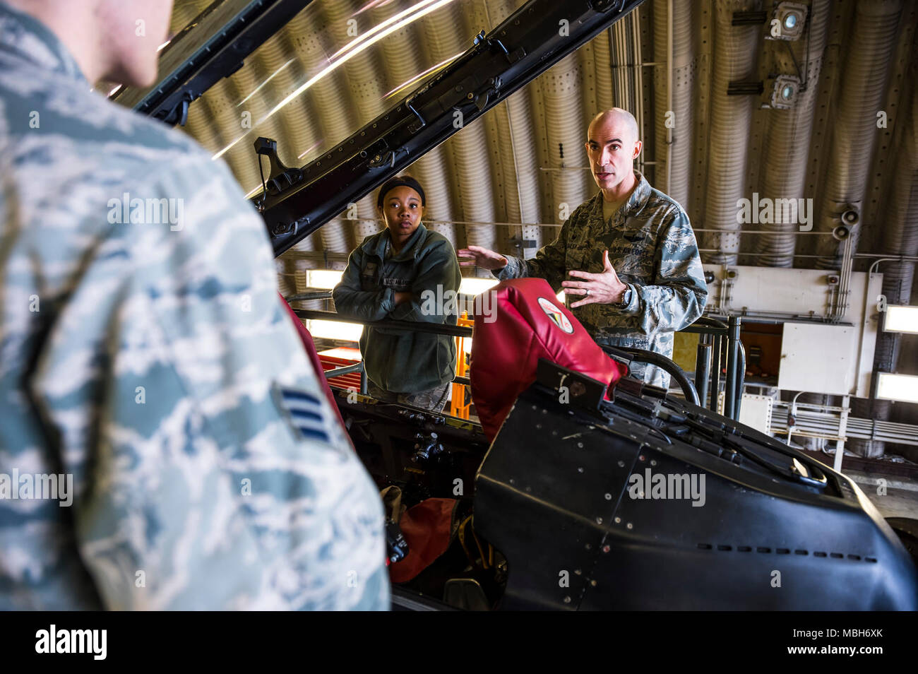 U.S. Air Force Col. Jason Bailey, 52nd Fighter Wing commander, educates Airman 1st Class Leah Crawford, 52nd Logistics Readiness Squadron fleet management analyst journeyman, and others about the different capabilities of an F-16 Fighting Falcon at Spangdahlem Air Base, Germany, April 4, 2018. Bailey explained the functions and capabilities of the aircraft as an opportunity to expand their knowledge of the flying mission at Spangdahlem. Stock Photo