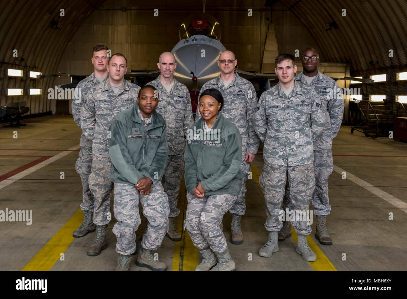 U.S. Air Force Col. Jason Bailey, 52nd Fighter Wing commander, and Chief Master Sgt. Christopher Vansile, 52nd FW acting command chief, pose with Airmen after a tour of an F-16 Fighting Falcon at Spangdahlem Air Base, Germany, April 4, 2018. The tour gave Airmen from around the 52nd FW an opportunity to meet the command team and expand their knowledge of flightline operations. Stock Photo
