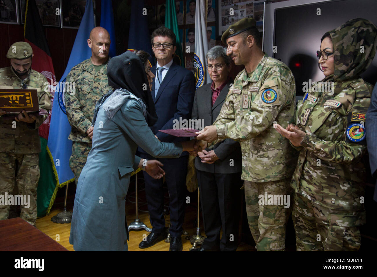 Afghan Lt. Col. M. Khetab Khangari, First General Command of Police Special Units commander, presents a certificate to a Female Foundation Course graduate as Australian Ambassador to Afghanistan Nicola Gordon-Smith and Norwegian Deputy Ambassador to Afghanistan John Almster look on at the Special Police Training Center, Camp Wak, Kabul, Afghanistan, Apr. 5, 2018. Stock Photo