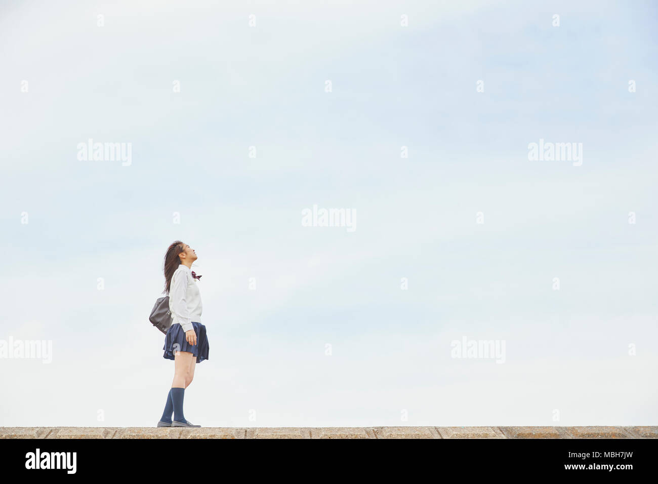 Cute Japanese high school student in a city park Stock Photo